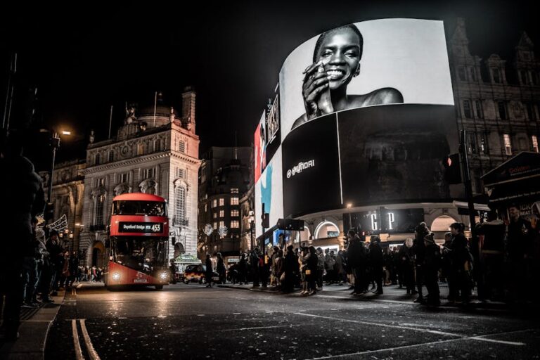 Vibrant city life at night in Piccadilly Circus, London with double-decker bus and illuminated billboards.